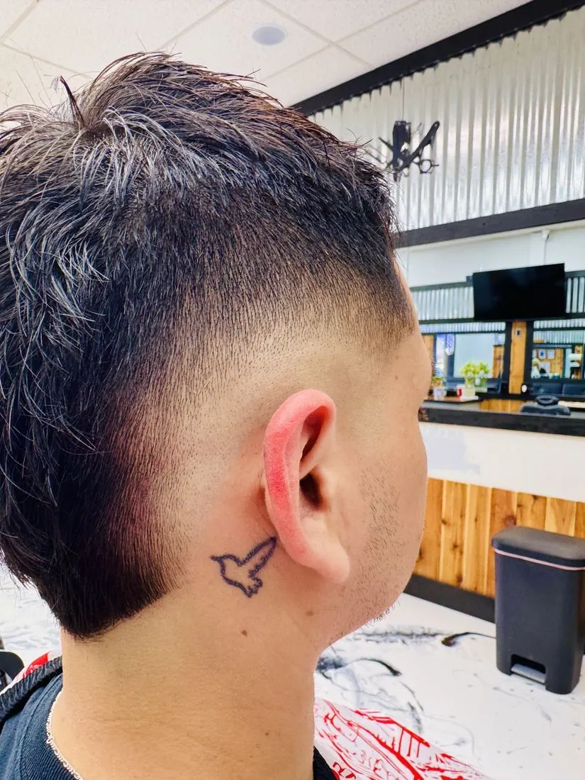 Skin fade with a sharp beard line, side view